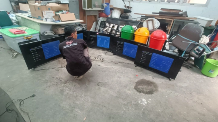 Teknisi profesional sedang melakukan service dan pengujian beberapa unit TV LED Samsung berukuran 40-55 inci secara bersamaan di sebuah kantor instansi wilayah Cikarang.